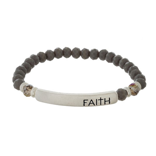 Beaded stretch bracelet with a bar focal, stamped with "Faith"